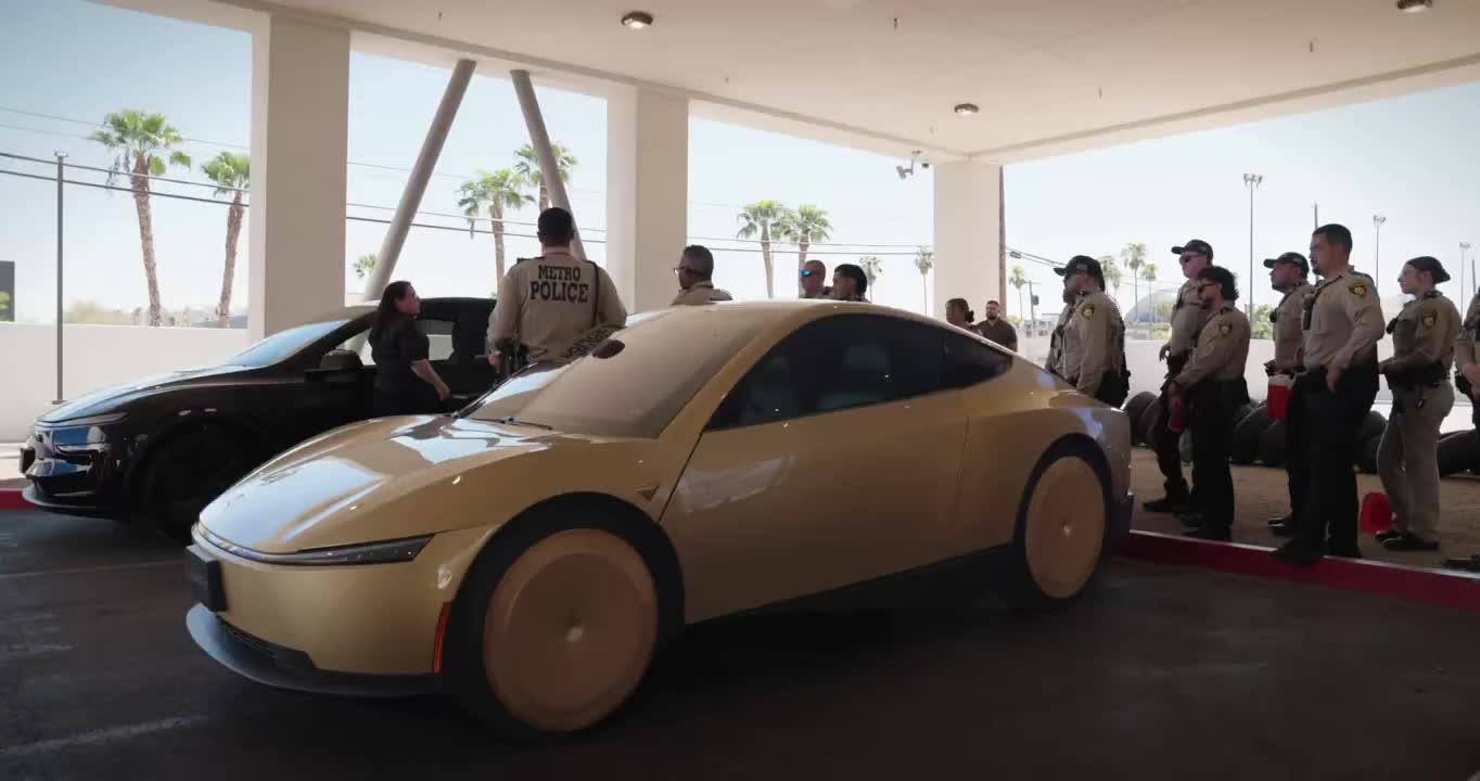 Gold Cybercab beside Metro Police under a canopy during a first-responder session.