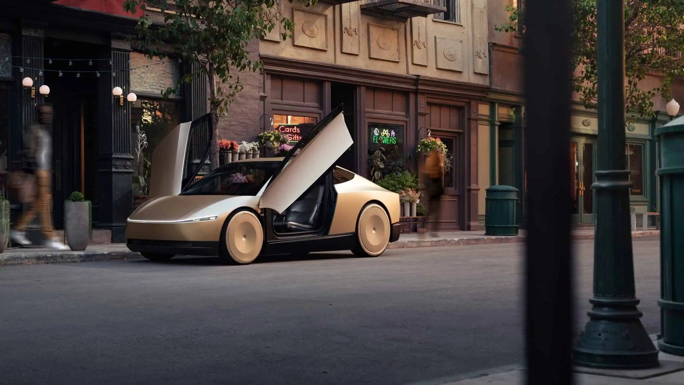A gold Tesla Cybercab with both doors raised, parked on a city street